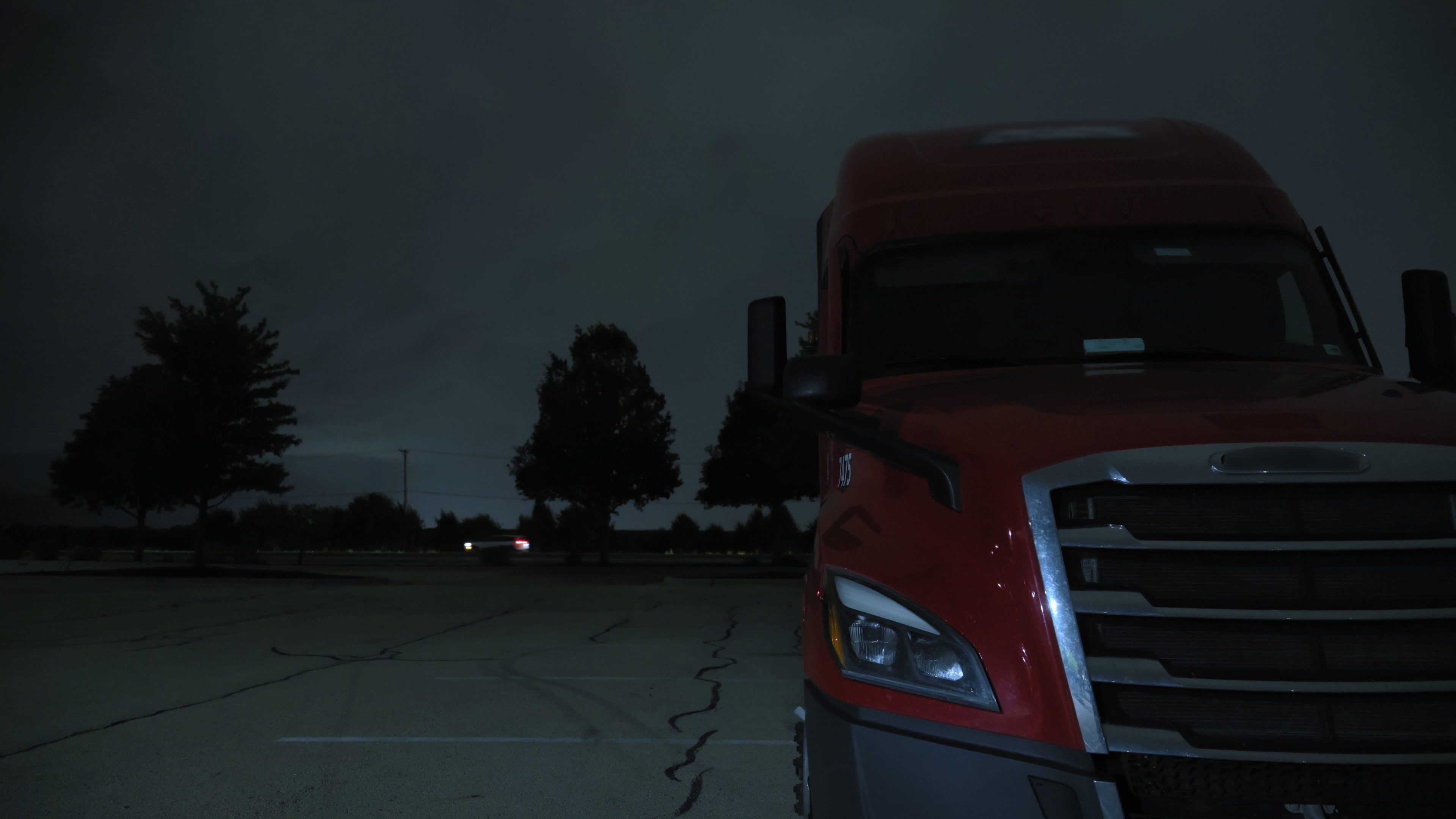 Semi truck parked under a stormy sky