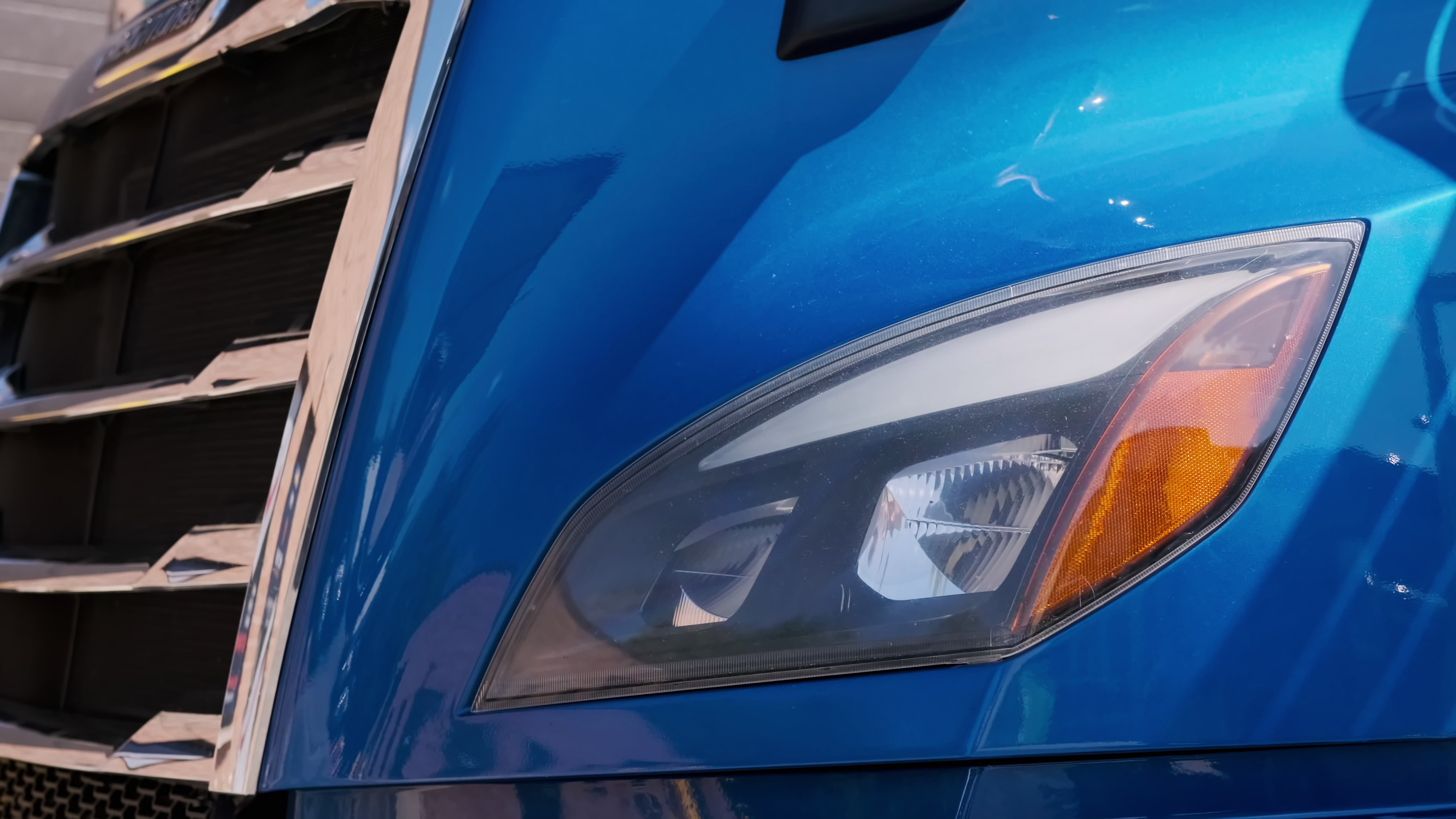 Close-up of a semi-truck headlight at a parking lot