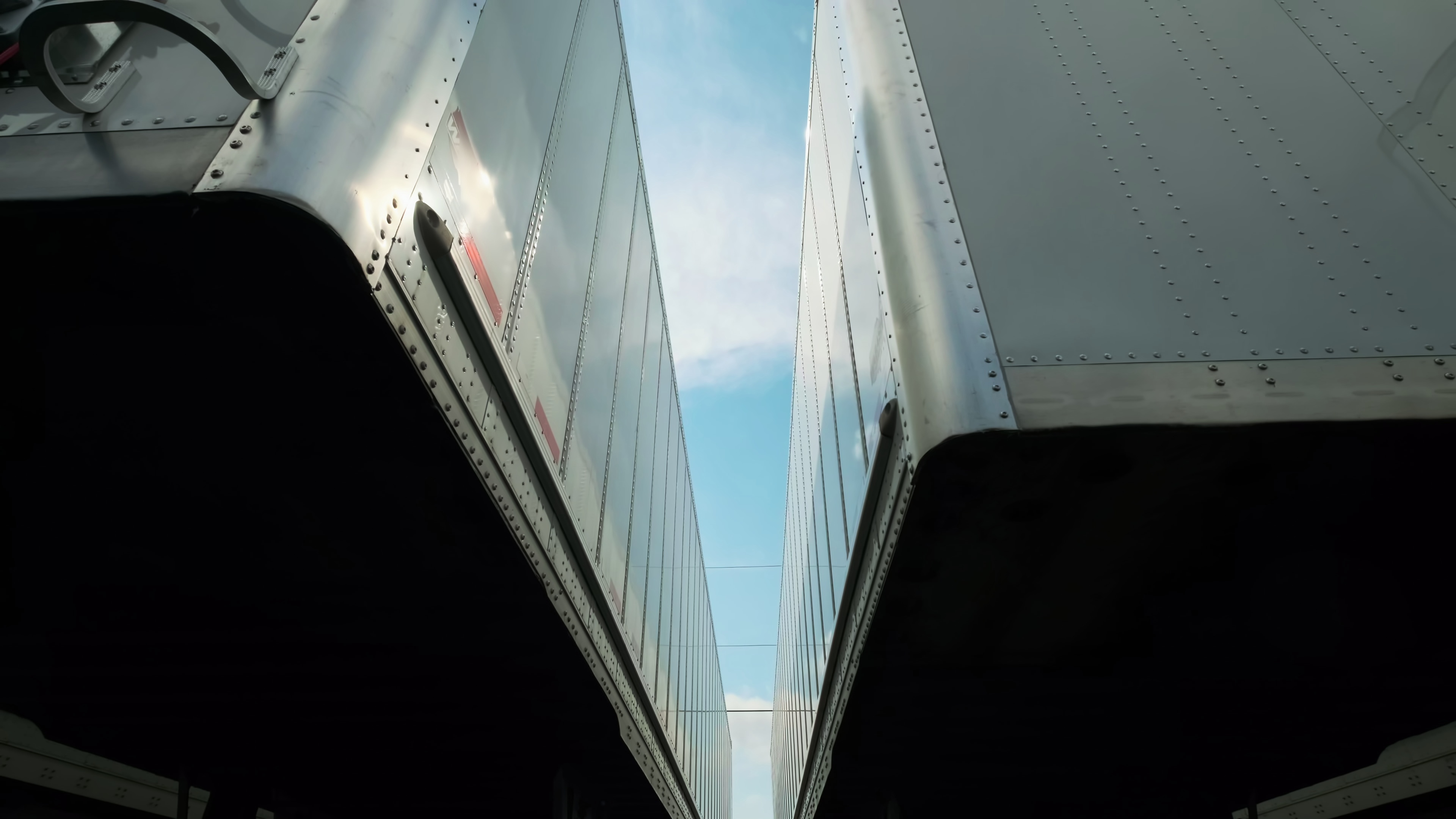 Many trucks and trailers parked in a lot