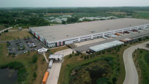Aerial drone view of a warehouse with semi-trucks and cargo trailers