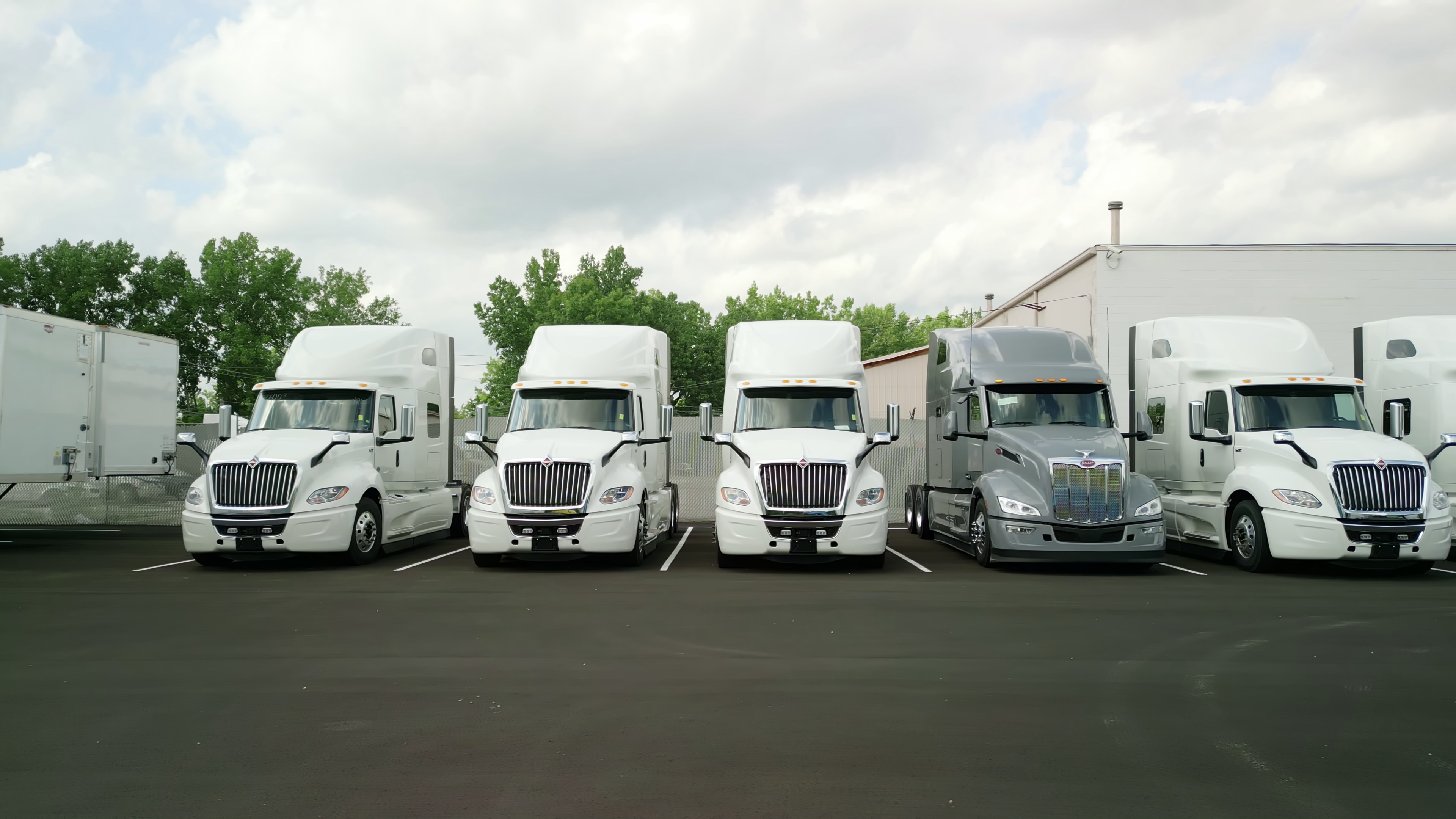 Wide shot of trucks parked in a commercial yard